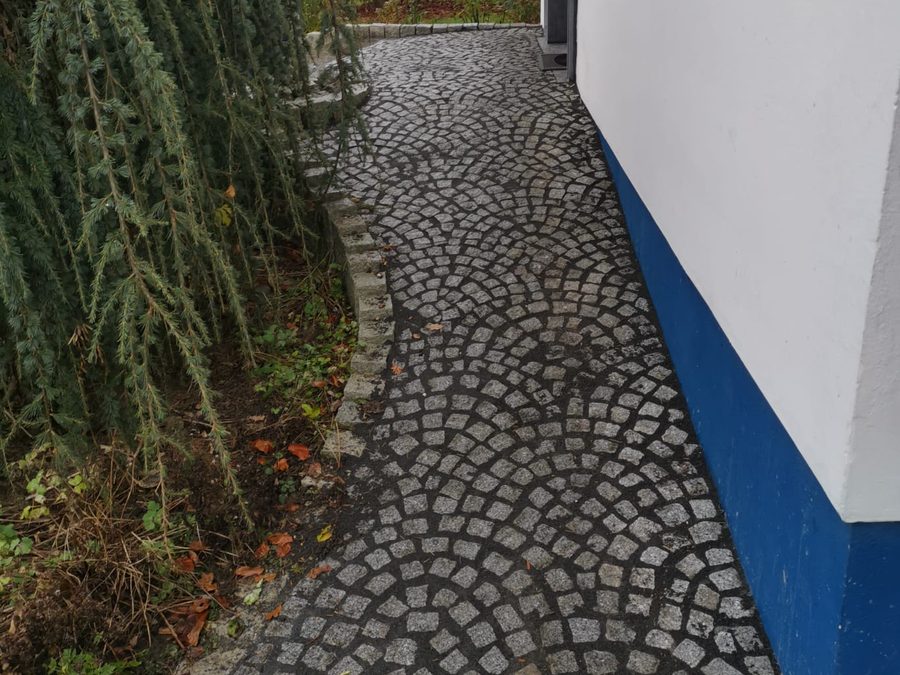 Seitlicher Hausweg aus Naturstein-Kleinpflaster im Bogenverband